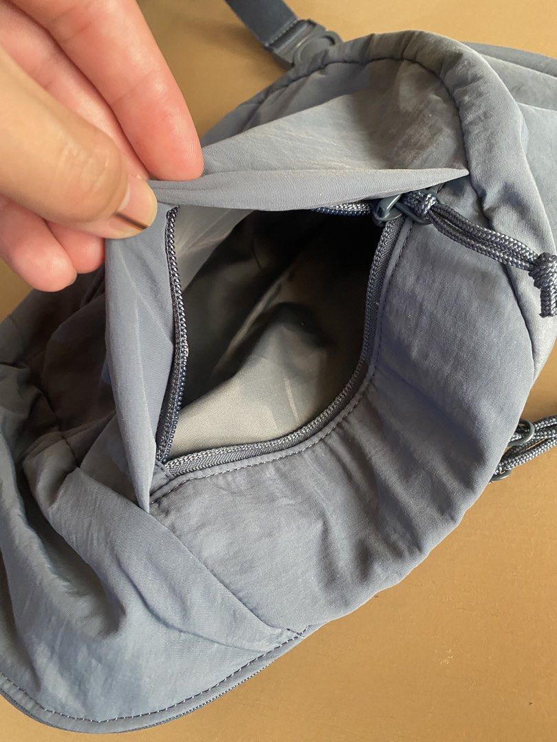 Uniqlo Grey Nylon Sling Bag (Category: Cross-body Bags) located in Baguio. Submitted by arenzu (Listing ID 1460948686, Image 3). Description: - Grey nylon sling bag - Adjustable strap with buckle closure - Main compartment with zip closure - Smaller zip pocket on the front - Interior slip pocket - Ideal for everyday use or travel - Lightweight and durable material.