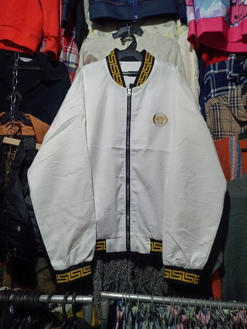 Versace White Bomber Jacket with Medusa Head Logo (Category: Luxury Apparel) located in Aguinaldo. Submitted by baguioukayukay2600 (Listing ID 1461007226, Image 1). Description: - White bomber jacket - Features iconic Medusa head logo on chest - Black and gold trim details - Zipper closure - Ribbed cuffs and hem - Versatile for casual or statement outfits - Sharp and stylish appearance.