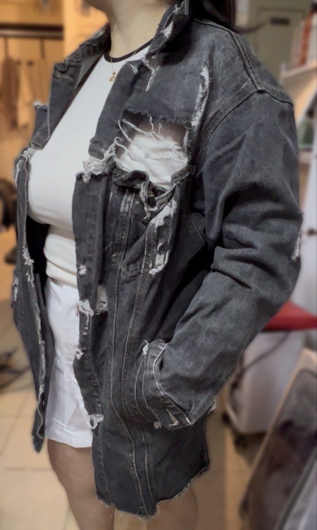 VETEMENTS Distressed Denim Jacket (Category: Coats, Jackets and Outerwear) located in Surigao. Submitted by boonz71_1971 (Listing ID 1461077278, Image 2). Description: Declutter Sale -unisex for men/women - Width 21” Length 27” - Brand: VETEMENTS - Type: Distressed Denim Jacket - Color: Faded Black - Size: Estimated Medium/Large - Features: Rips and tears throughout, button-up front, collar, long sleeves with frayed cuffs - Style: Bold statement 