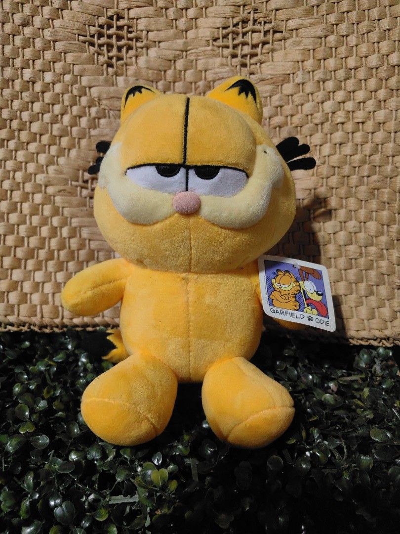 Vintage Garfield plush toy (Category: Plushies & Soft Toys) located in Calamba. Submitted by princesspauliney. (Listing ID 1461051061, Image 1). Description: Character: Garfield the Cat Brand/Manufacturer: GOSH International (Licensed under PAWS) Approximate Release Year: 2001 Features: Half-lidded expression, a round plush pink nose, soft fabric construction, and an attached character hang tag..