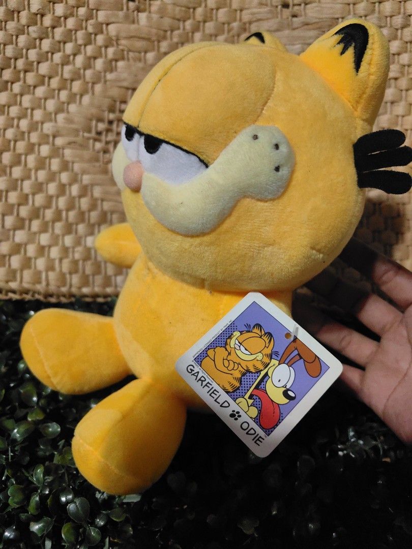 Vintage Garfield plush toy (Category: Plushies & Soft Toys) located in Calamba. Submitted by princesspauliney. (Listing ID 1461051061, Image 2). Description: Character: Garfield the Cat Brand/Manufacturer: GOSH International (Licensed under PAWS) Approximate Release Year: 2001 Features: Half-lidded expression, a round plush pink nose, soft fabric construction, and an attached character hang tag..