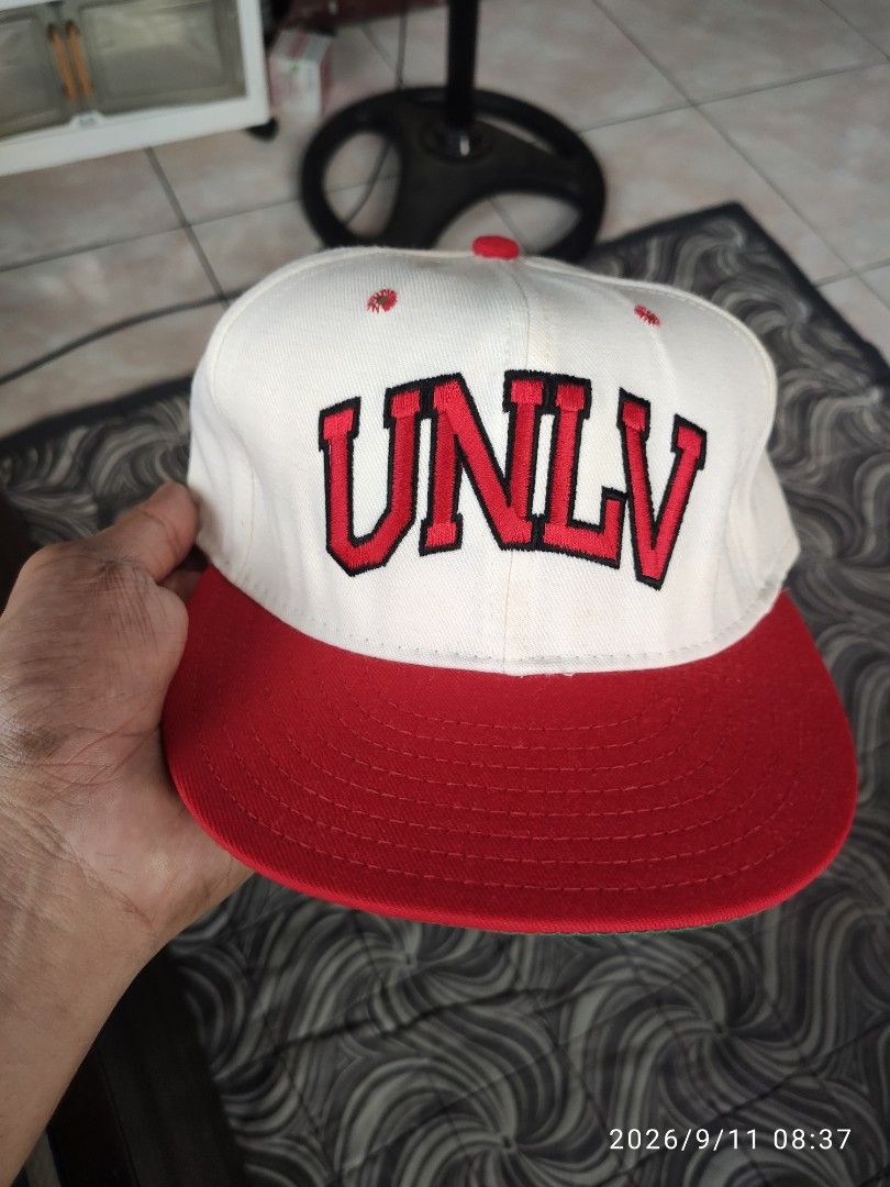 Vintage UNLV Rebels Snapback Cap Red White Green (Category: Caps & Hats) located in Las Pinas. Submitted by vtg_sakalam2021 (Listing ID 1460956000, Image 1). Description: - Classic UNLV Rebels snapback hat - White front with bold red lettering - Red brim with a cool green underbrim - Features a unique embroidered cartoon character on the side - Perfect for any UNLV fan! - fitted hat 7 1/2.
