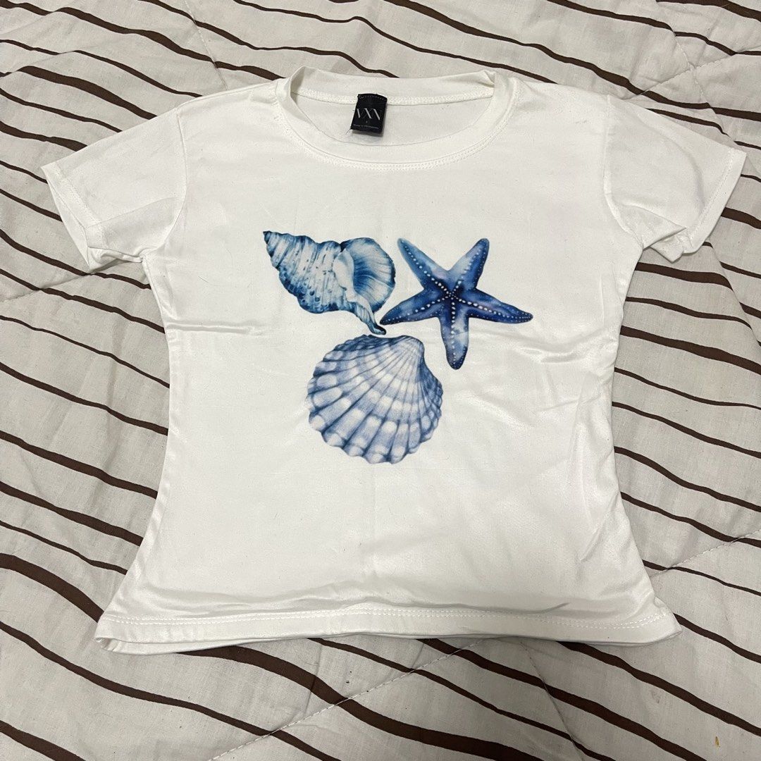 VXN Basic Y2K Top Blue Seashells (Category: Shirts) located in Manila. Submitted by ukhy_shop (Listing ID 1461090573, Image 1). Description: - Y2K Top Blue Seashells Graphic - Premium Cotton Material - Fitted Full lenght Top - Great fit: S 🛒— ₱90 ONLY dm to avail !!.