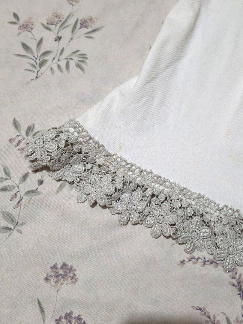 Whimsy fairy top white camisole (Category: Sleeveless) located in Taguig. Submitted by butterflypea.thrift (Listing ID 1460968320, Image 3). Description: - White ribbed camisole top - V-neckline with silver lace and rhinestone embellishments - Delicate silver lace trim on hem - Adjustable spaghetti straps - Versatile for layering or standalone wear.