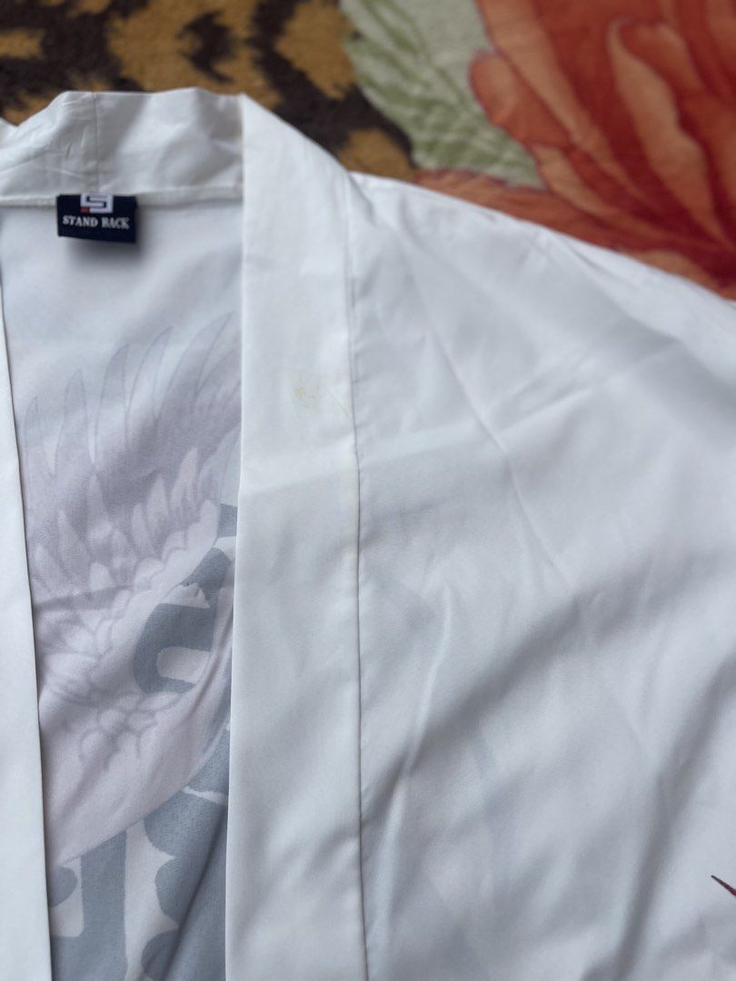 White Crane Print Kimono Jacket (Category: Coats, Jackets and Outerwear) located in Manila. Submitted by aikyy_ (Listing ID 1460923467, Image 3). Description: - White kimono jacket - Features a striking crane and cloud print - Large crane graphic on the back with Japanese calligraphy - Tag reads 'STAND BACK' - Minor stains on the front, visible in the last two photos (washable) - Ideal for stylish layering over any outfit.