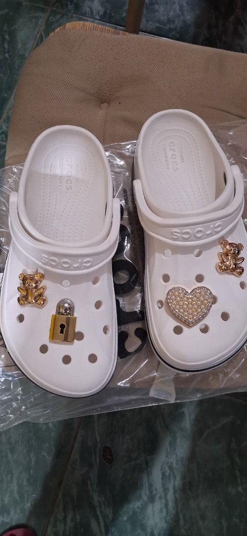 White Crocs with Teddy Bear, Lock, and Heart Charms (Category: Charms) located in Manila. Submitted by katkween23 (Listing ID 1460961692, Image 1). Description: - White Crocs - Decorated with cute charms: teddy bear, lock, and rhinestone heart - Easy to slip on and off - Perfect for casual wear and personal style.