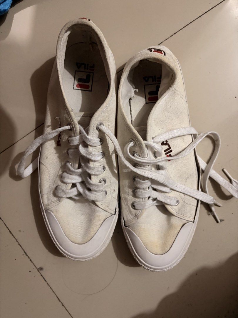 White Fila Canvas Sneakers (Category: Casual Shoes) located in Quezon City. Submitted by lesterdave23915 (Listing ID 1461088422, Image 1). Description: - Classic white Fila canvas sneakers - Low-top style with lace-up closure - Fila logo featured on insoles and heel tab - Minor yellowing and scuff marks on toe area - Plenty of wear left.