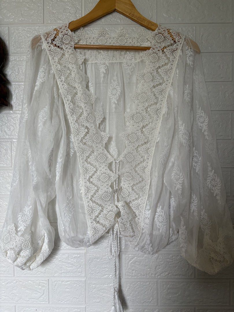 White Lace Trimmed Sheer Blouse (Category: Blouses) located in Batangas. Submitted by purple_and_orange (Listing ID 1460963711, Image 3). Description: - Sheer white blouse - V-neck with tie-up front - Long balloon sleeves - Intricate lace detailing on neckline and cuffs - Subtle embroidered pattern throughout fabric - Ideal for layering or a bohemian style.