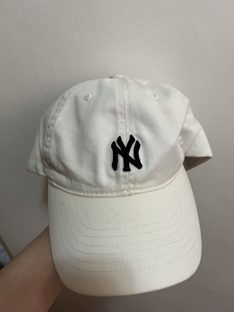 White New York Yankees MLB Baseball Cap (Category: Caps & Hats) located in Manila. Submitted by ertzn (Listing ID 1460941090, Image 1). Description: - Classic white baseball cap - Features iconic black embroidered New York Yankees 'NY' logo on the front - MLB logo embroidered on the back - Adjustable strap for a comfortable, customized fit - Ideal for everyday wear or showcasing your team pride.