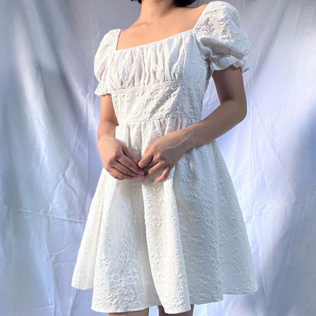 White Puff Sleeve Square Neck Textured Mini Dress (Category: Dresses) located in Manila. Submitted by demi.rewears (Listing ID 1461069755, Image 2). Description: White textured mini dress. Features puff sleeves and a square neck. Fitted bodice, flared skirt. Versatile style. Size: Fits Extra Small to Small (Tag: XS / Asian Fit) Bust: Fits 26” to 33” (13” flat lay) Waist: Fits 23” to 25” (12” flat lay) Length: 30” (Above the knee).