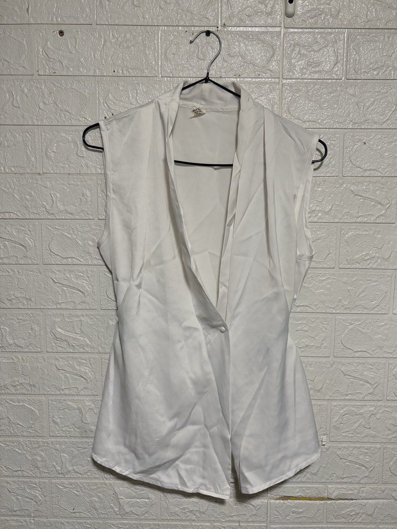 White Sleeveless Blouse (Category: Blouses) located in Manila. Submitted by _noname.shop (Listing ID 1461053986, Image 1). Description: - can fit to M-L - White sleeveless blouse - V-neckline - Single button closure at the front - Fabric with a slight sheen - Versatile for layering or wearing solo - Ideal for smart casual or office attire.