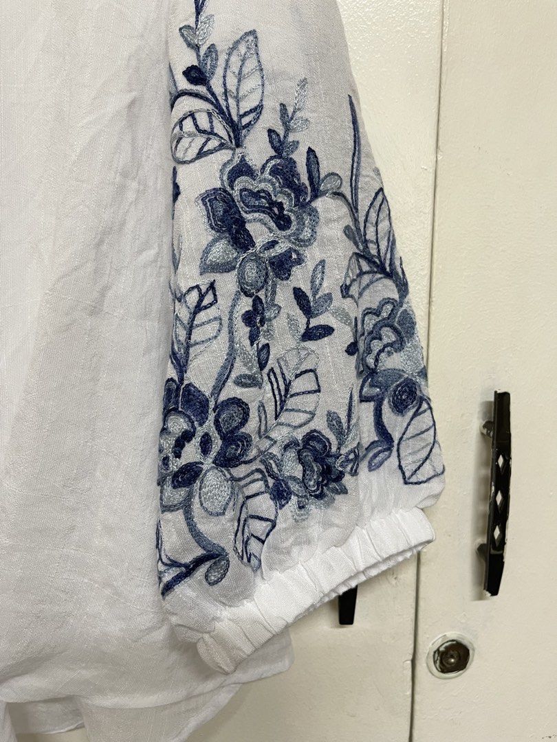 White V-neck Front-Tie Balloon Sleeve Blouse (Category: Blouses) located in San Juan City. Submitted by marthina.jacobo (Listing ID 1460965940, Image 3). Description: White V-neck tie-front blouse featuring blue floral embroidery on the balloon sleeves RFS: Decluttering Actual color may slightly vary due to lighting ₱280 + sf Modes of payment are through Unionbank/Metrobank/ GoTyme/ GCash.