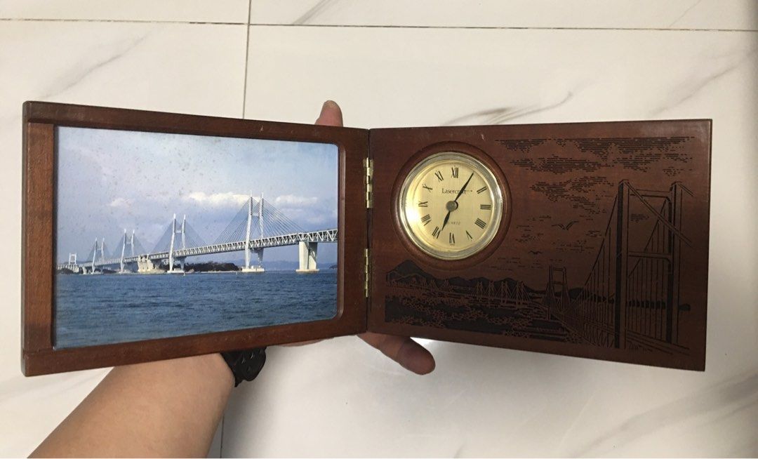 Wooden Desk Clock Photo Frame with Bridge Image (Category: Clocks) located in Pasay City. Submitted by gilbertso62551 (Listing ID 1461046685, Image 1). Description: - Wooden desk photo frame - For display only - Intricately carved with bridge and mountain scenery - Hinged design for easy self-standing display - Perfect for showcasing memories - Clock not working need repair - Missing battery cap - As is,where is - Wood, has weight - Need restorat