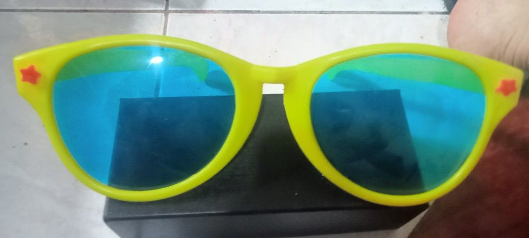 Yellow Oversized Star Sunglasses Blue Lenses (Category: Sunglasses & Eyewear) located in Paranaque City. Submitted by dimaguilaa94969 (Listing ID 1460960559, Image 1). Description: - Funky oversized sunglasses - Bright yellow frames - Blue lenses - Small red stars on the sides - Ideal for parties or costumes - Unique accessory - Ready for a new owner.
