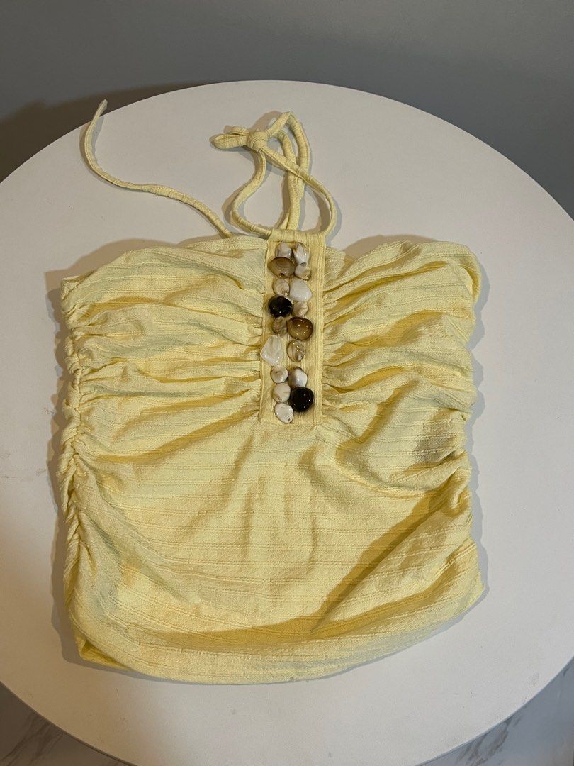Yellow Ruched Tube Top with Shell Embellishment (Category: Sleeveless) located in Manila. Submitted by xoshushi.dcltr (Listing ID 1460974532, Image 1). Description: - Adorable yellow tube top S-M - Features all-over ruching for a flattering fit - Decorated with a row of shell-like beads in the front - Adjustable tie-up straps for a custom fit - Ideal for a beachy look or casual outings.