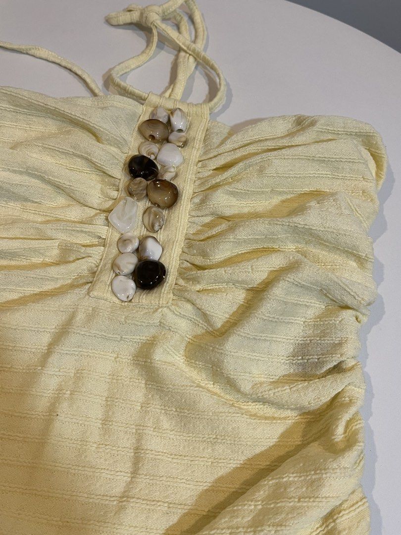 Yellow Ruched Tube Top with Shell Embellishment (Category: Sleeveless) located in Manila. Submitted by xoshushi.dcltr (Listing ID 1460974532, Image 2). Description: - Adorable yellow tube top S-M - Features all-over ruching for a flattering fit - Decorated with a row of shell-like beads in the front - Adjustable tie-up straps for a custom fit - Ideal for a beachy look or casual outings.