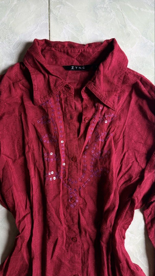 ZYNC Red Button-Up Shirt with Sequins - Size L (Category: Shirts) located in General Santos City (Dadiangas). Submitted by ssssshhhhhhhhh (Listing ID 1460949761, Image 2). Description: - ZYNC red long-sleeved shirt - Collared neckline with button-up front - Purple embroidery with sequins on chest - Textured fabric - Size: L.