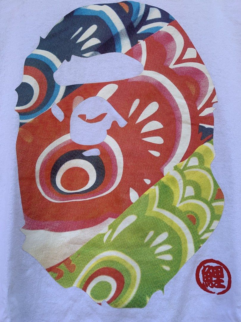 A Bathing Ape BAPE Tee Size M (Category: Tshirts & Polo Shirts ) located in Aloran. Submitted by chester78864 (Listing ID 1461286253, Image 2). Description: - Authentic White BAPE T-Shirt - Size: Medium (M) - Features a colorful, eye-catching ape head graphic - Ideal for streetwear fashion lovers - High-quality print details.