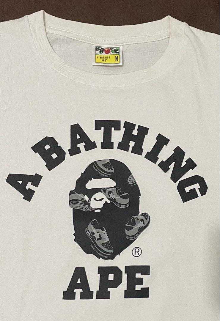 A Bathing Ape White T-Shirt Size M (Category: Tshirts & Polo Shirts ) located in Manila. Submitted by jkm_g (Listing ID 1461272312, Image 2). Description: - White A Bathing Ape (BAPE) T-shirt - Features the iconic ape head logo with sneakers graphic - Size: Medium (M) - Ideal for streetwear fashion - Versatile: pairs well with jeans or shorts - A must-have iconic piece.