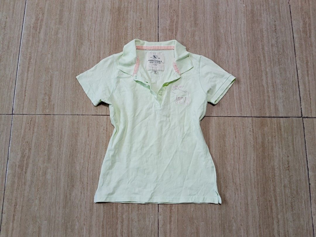 Abercrombie & Fitch womens top (Category: Activewear) located in Glan. Submitted by cpaharodde48008 (Listing ID 1461323624, Image 1). Description: - Cute light green Abercrombie & Fitch kids' polo shirt - Features a small embroidered bunny on the chest - Pink trim inside the collar for a pop of color - Short sleeves and button-up neckline - Ideal for everyday casual wear.
