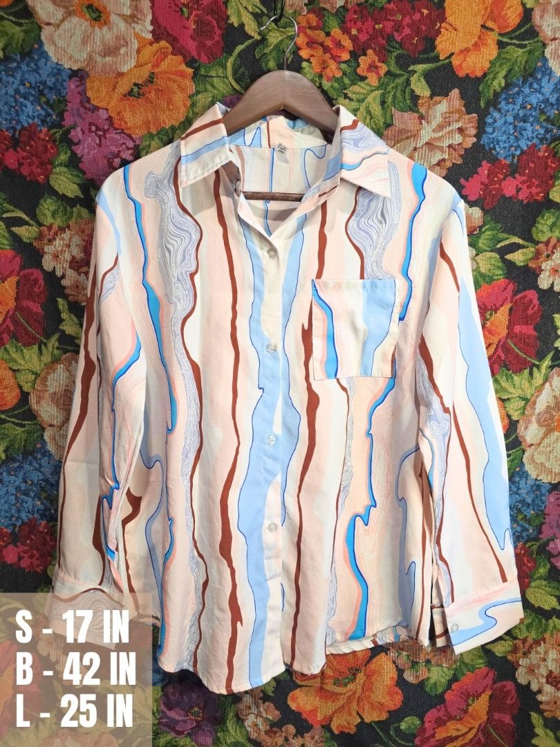 Abstract Print Button-Up Shirt (Category: Tshirts & Polo Shirts ) located in Paranaque City. Submitted by titaartestudio (Listing ID 1461254551, Image 1). Description: - Eye-catching abstract print with brown, blue, and pink vertical lines. - Left chest pocket for added detail and functionality. - Classic button-up front with a neat collar. - Long sleeves with button cuffs for a polished finish. .
