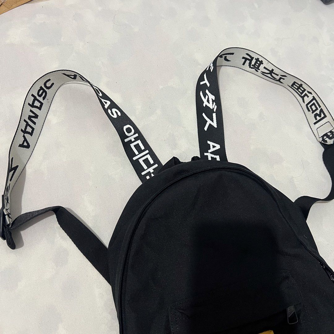 Adidas Mini Backpack Black with Text Straps (Category: Backpacks) located in Las Pinas. Submitted by silent_greich (Listing ID 1461226944, Image 3). Description: - Bought for 3k. - Black Adidas mini backpack - Classic Adidas logo on a yellow patch - Straps feature unique text (Japanese/Korean etc characters) - Front zip pocket for easy access - Ideal for carrying essentials - Great for daily use or travel.