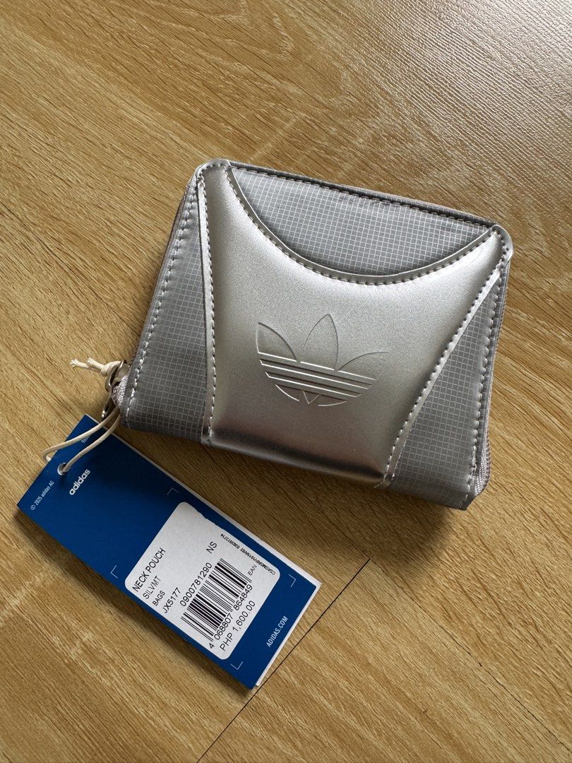 Adidas Neck Pouch Silver Metallic JX5177 (Category: Purses & Pouches) located in Manila. Submitted by helloseptembermnl (Listing ID 1461130001, Image 1). Description: - Brand: Adidas - Model: JX5177 - Color: Silver Metallic - Condition: Brand new with original tag - Features: Zip closure, ideal for carrying essentials - Design: Clean and minimalist.