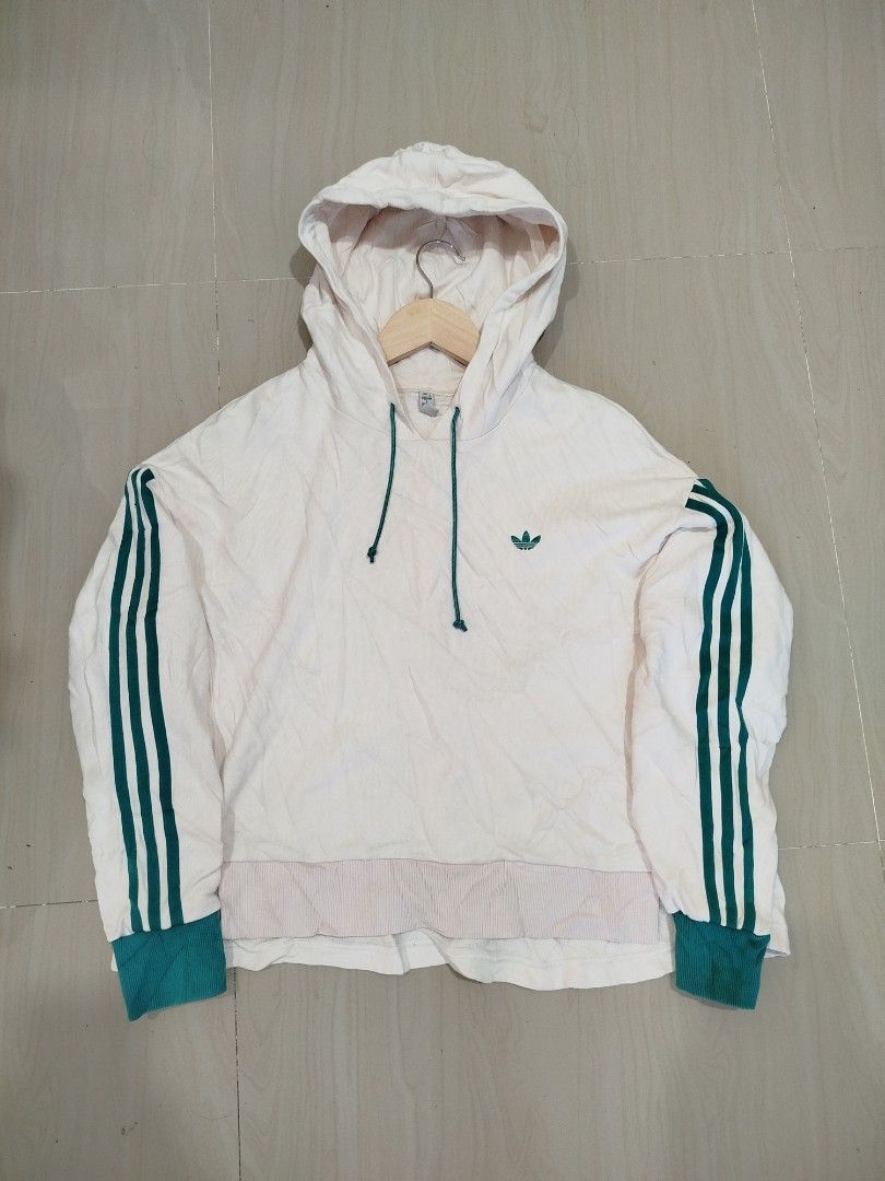 Adidas TRF Trefoil oversized pullover hoodie (Category: Coats, Jackets and Outerwear) located in Aroroy. Submitted by dr0p-a-dr1p (Listing ID 1461285646, Image 2). Description: - Classic white Adidas hoodie - Iconic green stripes on sleeves - Small green trefoil logo on front - Large trefoil graphic on back - Adjustable drawstring hood - Cuffed sleeves for a snug fit - Relaxed fit, perfect for everyday casual wear.