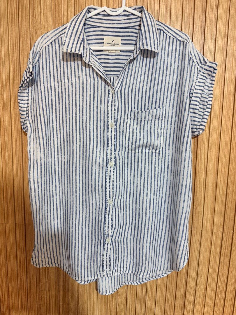 American Eagle Outfitters Striped Button-Up Shirt (Category: Shirts) located in Makati City. Submitted by ziagabrielle (Listing ID 1461142788, Image 2). Description: - Brand: American Eagle Outfitters - Color: Blue and white stripes - Style: Button-up shirt - Sleeves: Short with rolled cuffs - Features: Single chest pocket - Material: Lightweight - Occasion: Casual wear - Styling: Easy to pair with various outfits -W21xL29.