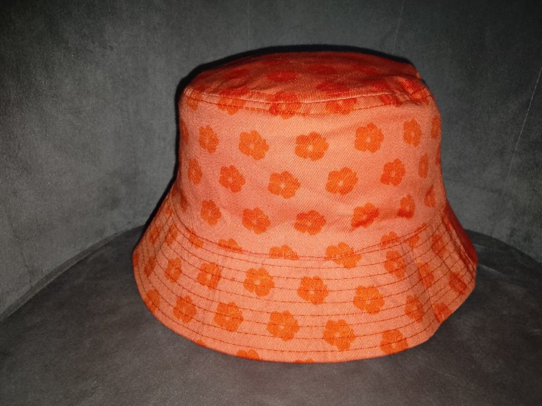 AOP Floral Bucket Hat (Category: Hats & Beanies) located in Binangonan. Submitted by yuristalin888 (Listing ID 1461308132, Image 3). Description: Bring a piece of Hawaiian paradise to your accessory collection with this vibrant orange bucket hat. The hat features a playful, all-over floral pattern in a slightly darker orange hue. Prominently embroidered on the front in white thread is the text "INTERNATIONAL MARKET PLACE" above "WAIKIKI". Crafted