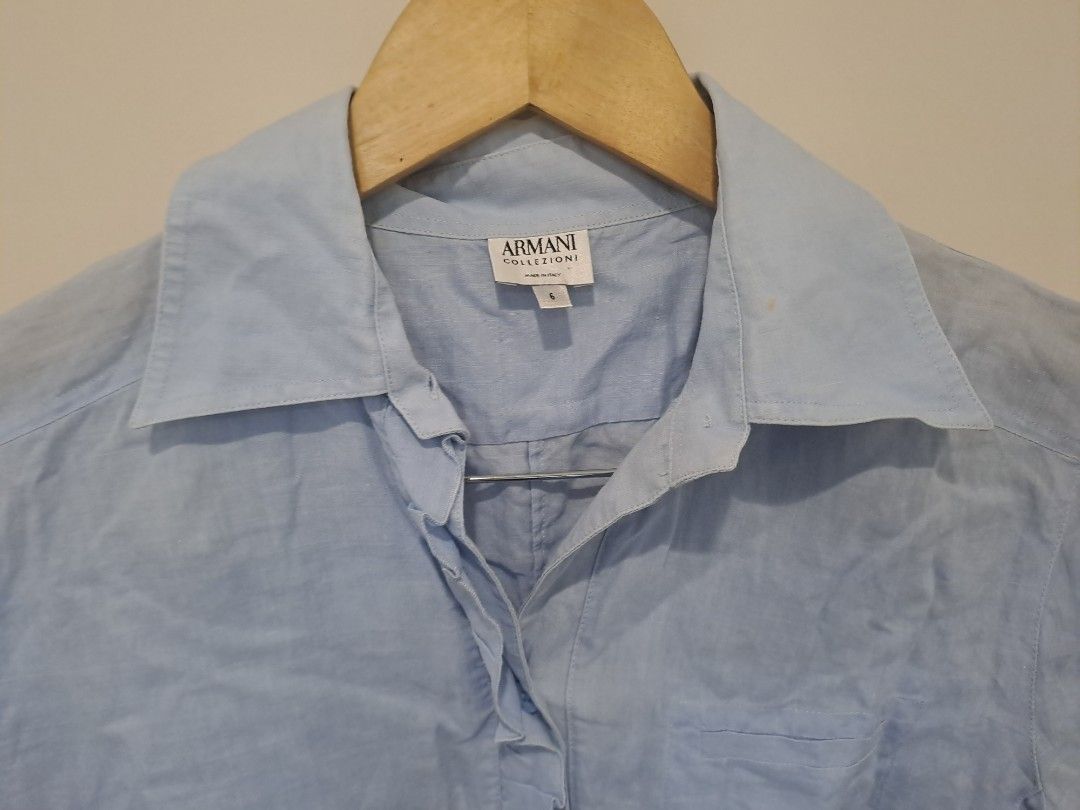 Armani collections Linen (Category: Longsleeves) located in Manila. Submitted by joanbalde39643 (Listing ID 1461226909, Image 3). Description: This is an Armani Collezioni light blue linen blouse featuring a classic collar, button-up front, and distinct raw-edge ruffle detailing along the central placket and hemline. small to medium..