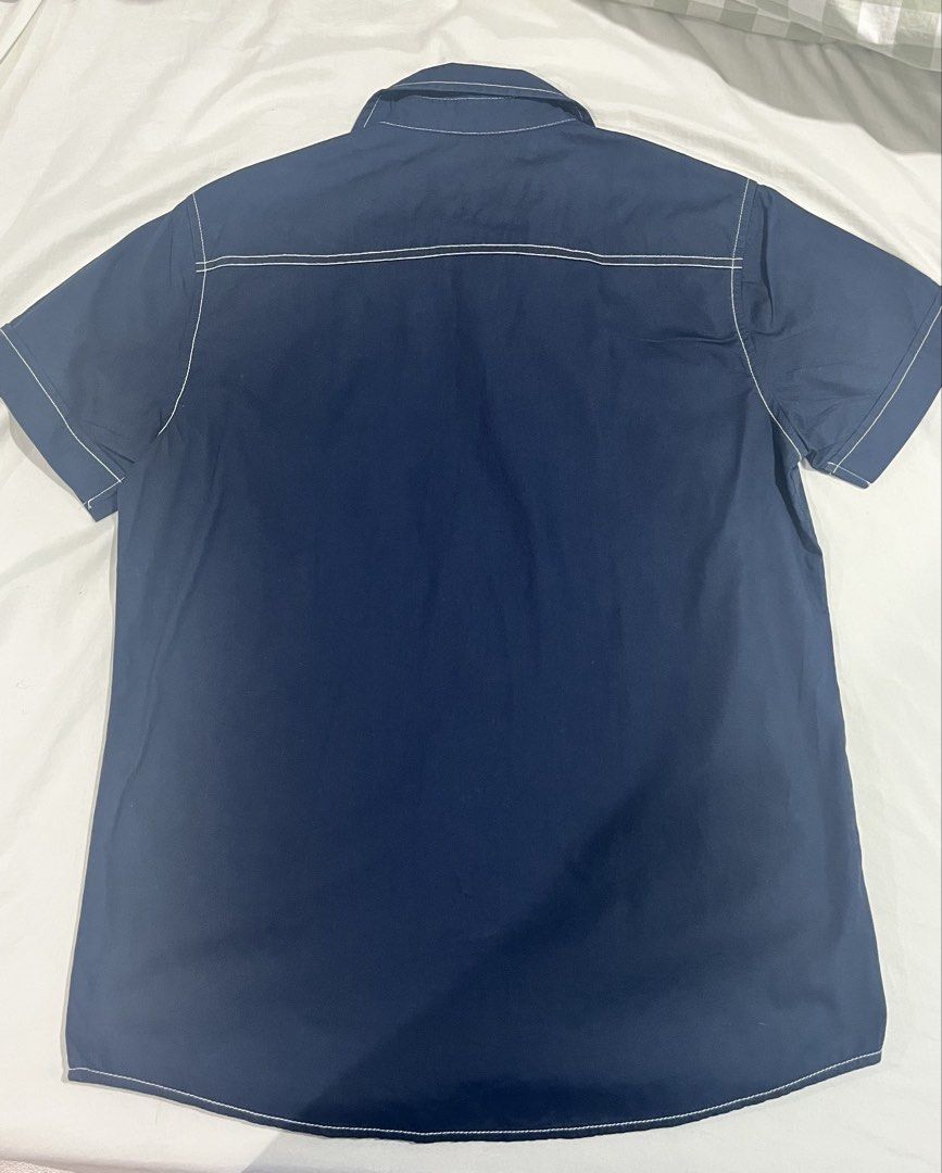 Authentic Wrangler Short Sleeve Button Up Shirt Size S (Category: Tshirts & Polo Shirts ) located in Quezon City. Submitted by angelo1412 (Listing ID 1461271262, Image 3). Description: - Brand: Wrangler - Color: Navy Blue - Original Price: ₱1,400 - Has no stain, rip, etc:) - Sleeve Length: Short Sleeve - Size: S - Details: White contrast stitching throughout, single chest pocket with pointed flap, button-up front - Style: Casual wear.