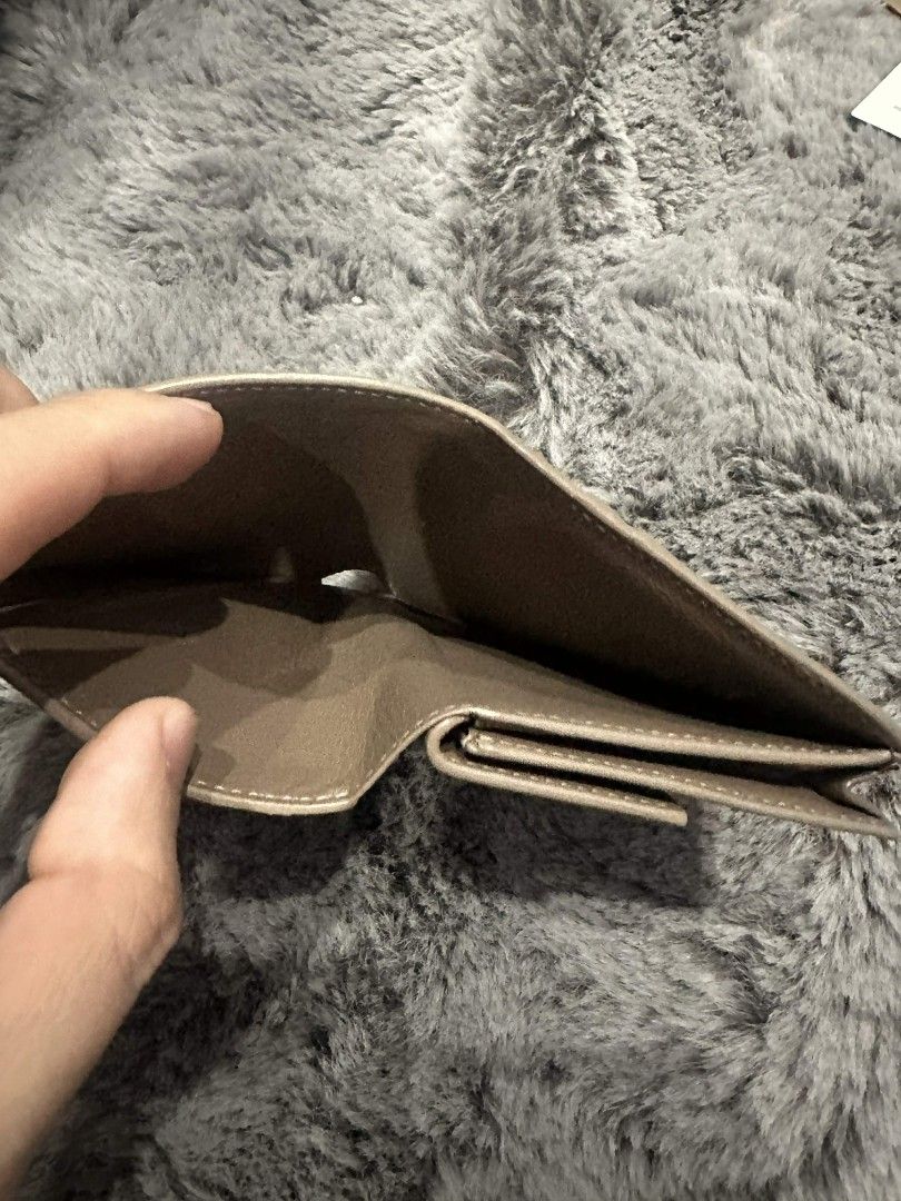 Balenciaga Leather Bifold Wallet (Category: Luxury Bags & Wallets) located in Mandaluyong City. Submitted by calibre915 (Listing ID 1461153993, Image 3). Description: - Authentic Balenciaga bifold wallet - Chic taupe leather - Multiple card slots for organization - Secure coin pocket with snap closure - Subtle embossed Balenciaga logo on the front - Immaculate interior condition - Ideal for everyday essentials.
