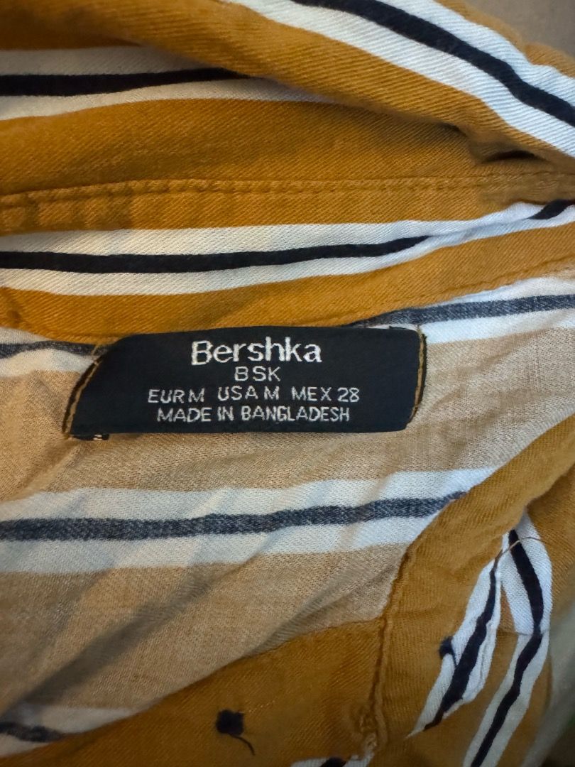 Bershka Striped Button-Up Shirt (Category: Shirts) located in Manila. Submitted by missalmon (Listing ID 1461254669, Image 2). Description: L: 17 inches W: 23.5 inches Loose fit Square fit Striped With 1 pocket .