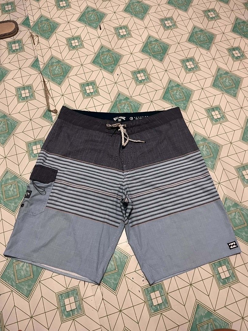 Billabong Striped Board Shorts (Category: Swim Trunks & Board Shorts) located in Manila. Submitted by _lemornosnas02 (Listing ID 1461153458, Image 1). Description: - Brand: Billabong - Style: Board Shorts - Color: Blue and Grey striped pattern - Features: Back velcro pocket with Billabong logo, drawstring waist for adjustable fit - Ideal for: Swimming, lounging, beach activities -location iloilo -plus ship via lbc.
