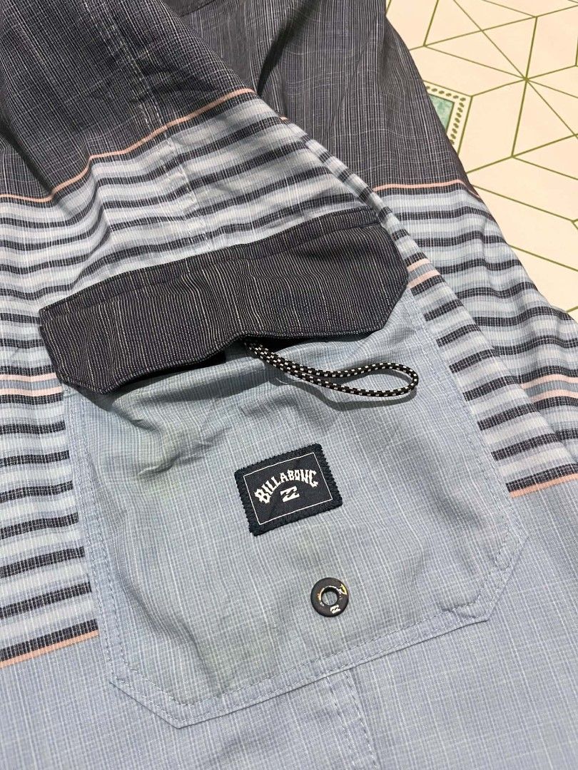 Billabong Striped Board Shorts (Category: Swim Trunks & Board Shorts) located in Manila. Submitted by _lemornosnas02 (Listing ID 1461153458, Image 2). Description: - Brand: Billabong - Style: Board Shorts - Color: Blue and Grey striped pattern - Features: Back velcro pocket with Billabong logo, drawstring waist for adjustable fit - Ideal for: Swimming, lounging, beach activities -location iloilo -plus ship via lbc.
