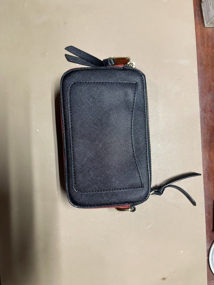 Black & Red Marc Jacobs Snapshot Pouch (Category: Luxury Bags & Wallets) located in Cainta. Submitted by d3clutterw0rld (Listing ID 1461301487, Image 3). Description: - Black saffiano leather pouch - Red trim detail - Gold Marc Jacobs logo on front - Double zip closure - Blue interior lining - Small strap with tassel detail - Note: Slight wear on the strap end - Ideal for cards, cash, or small essentials.