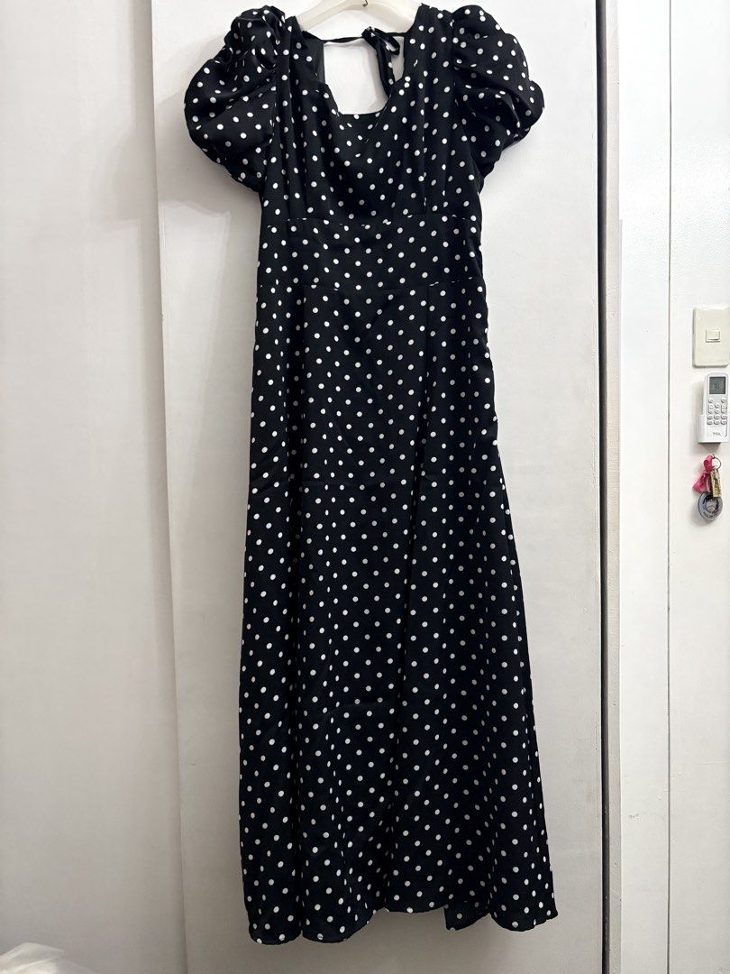Black Polka Dot Puff Sleeve Maxi Dress (Category: Dresses) located in Quezon City. Submitted by thebutingthings (Listing ID 1461280163, Image 1). Description: - Elegant black maxi dress with classic white polka dots. - Stylish puff sleeves add a touch of flair. - Adjustable tie-back detail at the neckline for a customized fit. - Flattering smocked bodice ensures comfort and a great silhouette. - Versatile piece: dress it down for casual days or u