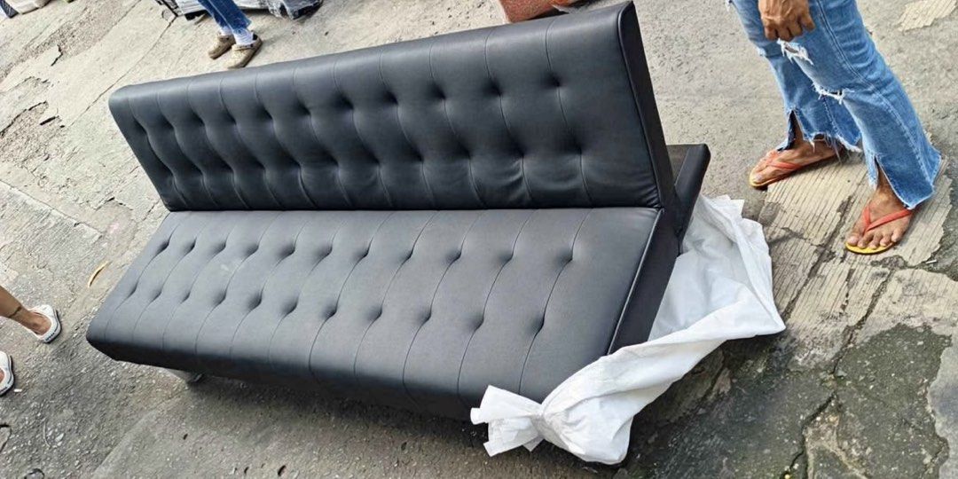 Black Tufted Sofa Bed - Folds Flat (Category: Sofas) located in Manila. Submitted by decluttergly (Listing ID 1461271271, Image 2). Description: - Stylish black sofa bed with elegant tufted upholstery. - Versatile: Use as a comfortable couch or fold down flat into a bed. - Durable faux leather material for a sleek look. - Sturdy and simple metal legs. - Ideal space-saving solution for apartments or smaller rooms. - Effortless conversion between s