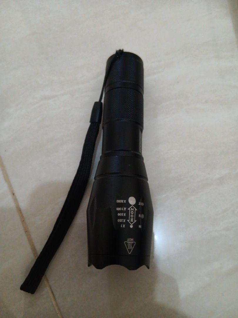 Black Zoomable LED Flashlight with Lanyard (Category: Home Improvement Tools & Accessories) located in Manila. Submitted by ocyobe4man (Listing ID 1461160533, Image 1). Description: - Bright Black LED Flashlight - Adjustable Zoom: X1, X250, X500, X1000, X2000 - Zoom Indicator: 'IN' and 'OUT' labels - Safety Feature: 'HOT' warning symbol on body - Includes convenient lanyard - Ideal for outdoor adventures and emergency preparedness.