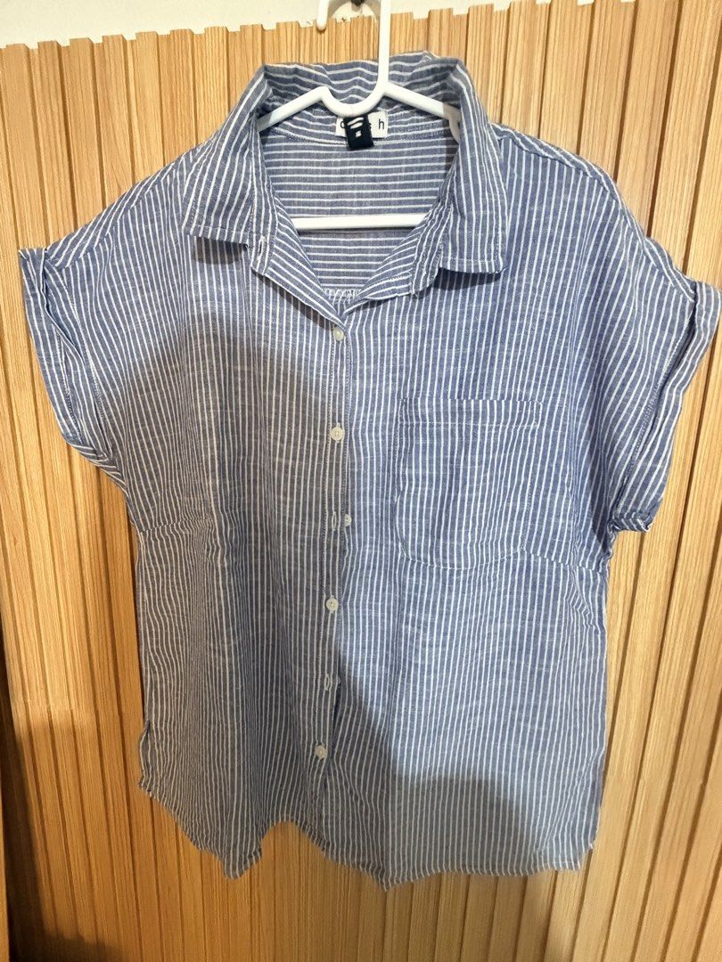 Blue and White Striped Button-Up Shirt (Category: Shirts) located in Makati City. Submitted by ziagabrielle (Listing ID 1461141161, Image 1). Description: - Casual short-sleeved shirt - Blue and white vertical stripes - Chest pocket - Button-up front - Cuffed sleeves - Comfortable for everyday wear - Easy to style with jeans or shorts -W22xL26.