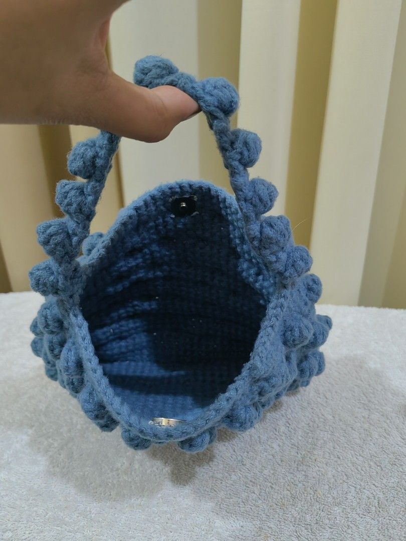 Blue Crochet Bobble Handbag with Handle (Category: Tote Bags) located in Makati City. Submitted by prelovedtreatedwithlove (Listing ID 1461319492, Image 2). Description: - Adorable blue crochet handbag - Unique all-over bobble texture - Sturdy handle for comfortable carrying - Secure snap button closure inside - Compact size, ideal for essentials - Handmade item - Perfect for casual outings and everyday use - no issue.