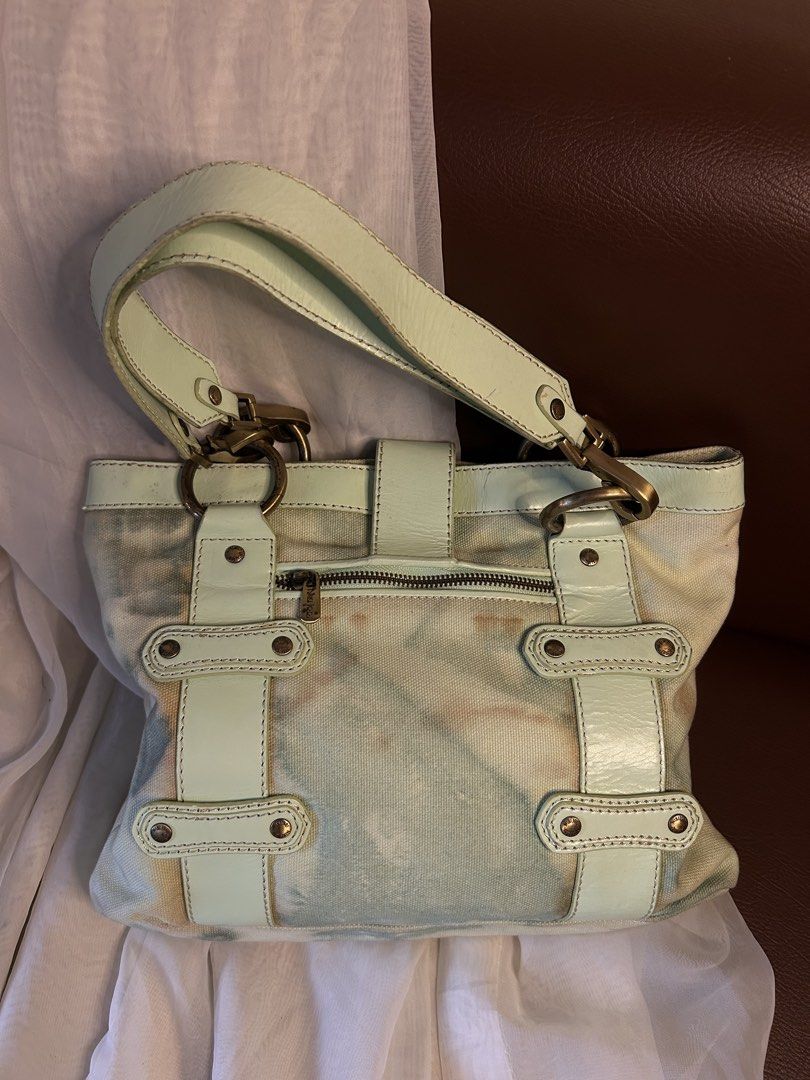 CANVAS NIKI JODI SHOULDER BAG (Category: Shoulder Bags) located in Baguio. Submitted by chmlnstudio (Listing ID 1461189439, Image 2). Description: Product Details ✦ Brand: Niki Jodi ✦ Style: Canvas & Leather Accent Tote / Shoulder Bag ✦ Colorway: Cream canvas base with mint green leather trim — length: 18” — width: 14” Features: ⟢ Front flap closure with antique brass dog-clip detail and signature enamel ribbon logo charm ⟢ Dual shoulder straps +