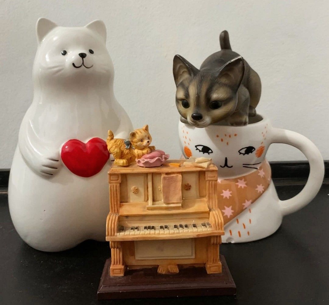 Cat Figurines Set and Mug (Category: Looking For) located in Quezon City. Submitted by dfabloveverything (Listing ID 1461215544, Image 1). Description: - Adorable set of cat figurines - Includes a large white cat holding a heart - Features a smaller piano with two kittens - Comes with a mug showcasing a cat face and a peeking tabby cat -minimal chip on bottom part - Ideal for cat lovers and collectors - Adds a whimsical touch to shelves or desks 