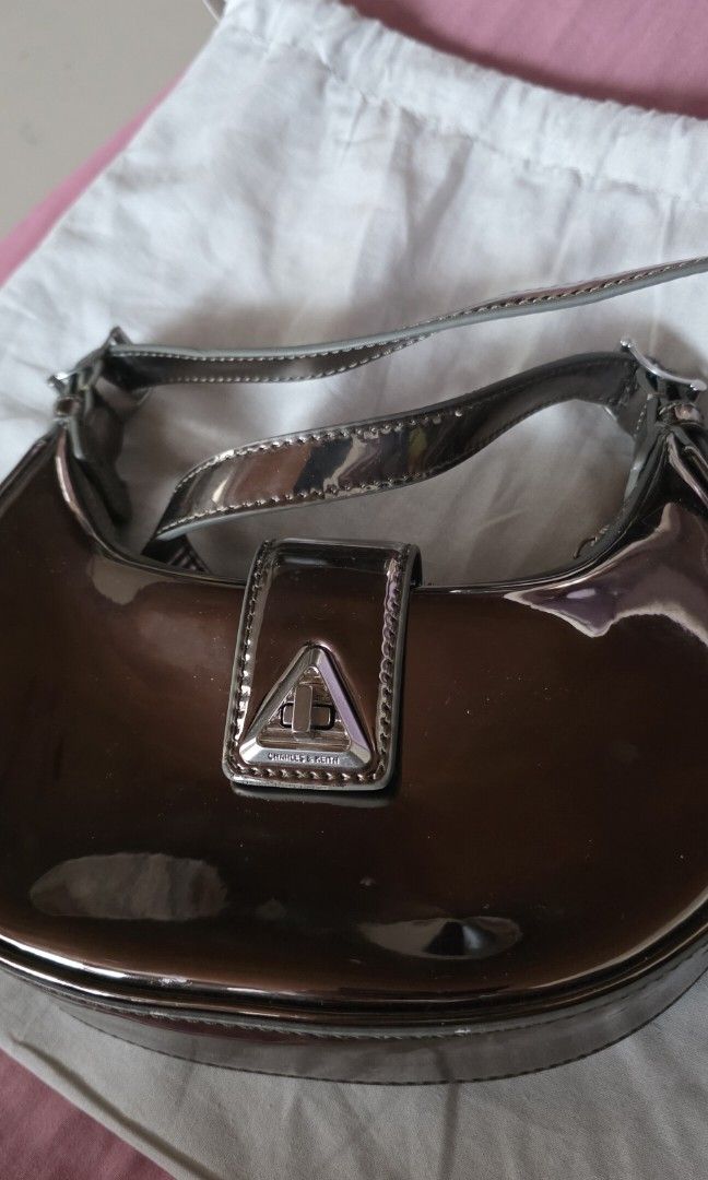 Charles & Keith Metallic Shoulder Bag (Category: Shoulder Bags) located in Santa Maria. Submitted by ellahqy28 (Listing ID 1461190346, Image 3). Description: - Brand: Charles & Keith - Style: Shiny metallic shoulder bag - Design: Unique curved shape - Closure: Silver buckle - Included: Original dust bag - Features: Adds shine to outfits, perfect size for essentials.