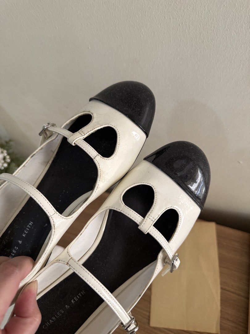 Charles & Keith White & Black Cap Toe Mary Jane Flats (Category: Flats & Sandals) located in Manila. Submitted by artyreal (Listing ID 1461168324, Image 2). Description: - White patent flats with classic black cap toes - Features a stylish Mary Jane strap with buckle closure - Charles & Keith logo detail on insole and sole - Size: 38.