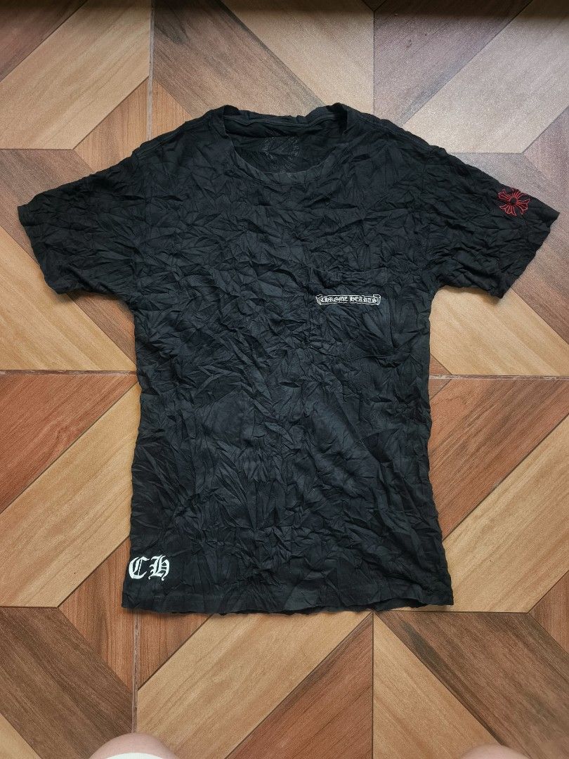 Chrome Hearts (Category: Tshirts & Polo Shirts ) located in Zamboanga. Submitted by d2977250664046 (Listing ID 1461242120, Image 1). Description: - Black Chrome Hearts Pocket T-shirt - Size XS on tag (17x25-26) - Features iconic Chrome Hearts logo on chest pocket - Additional CH logo detail on the bottom hem - Subtle red cross detail on the sleeve - Unique crinkled fabric texture - Ideal for stylish casual wear - No Flaws (NeedWash).