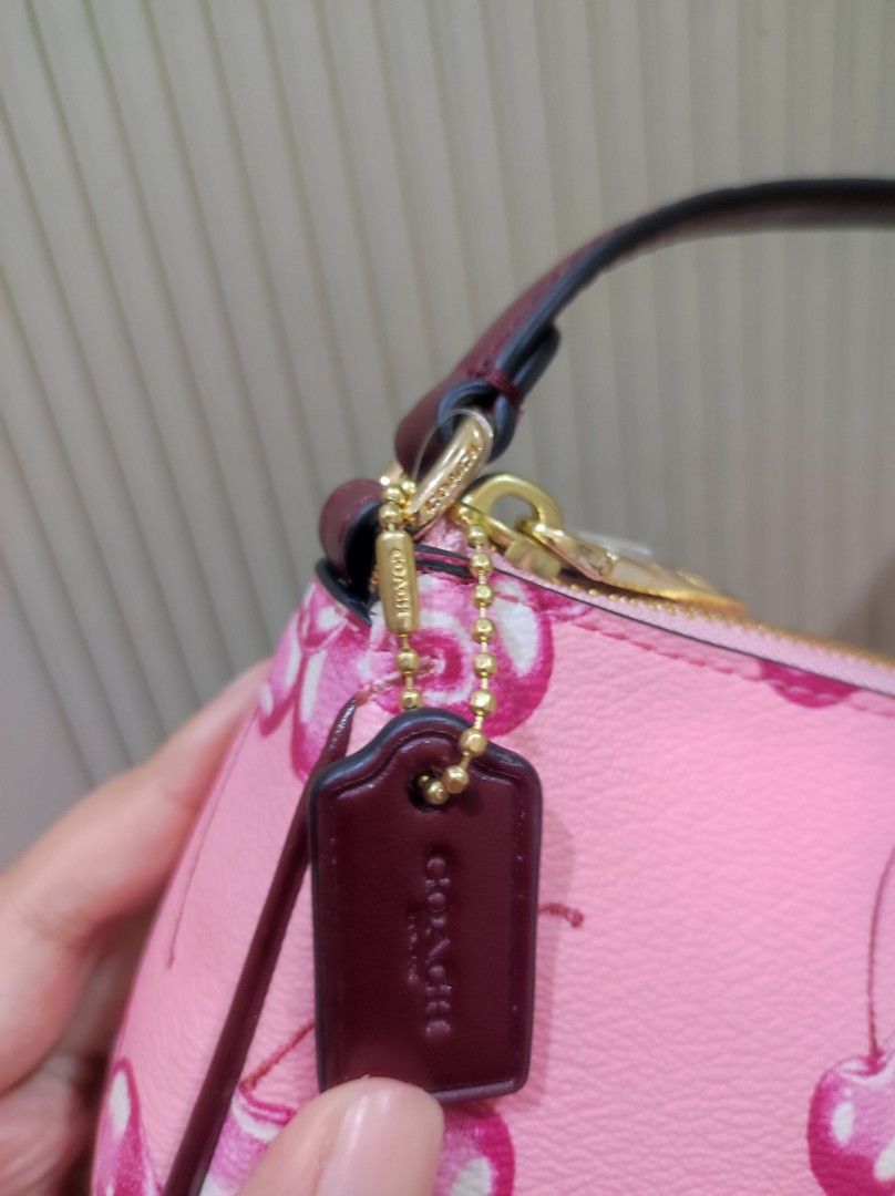 Coach Nolita 19 Pink Cherry Print (Category: Luxury Bags & Wallets) located in Marikina City. Submitted by kylacastillo03 (Listing ID 1461240100, Image 2). Description: - Original and Brandnew. Moneyback Guaranteed if proven fake. - Pink cherry print design - Compact, small size - perfect for essentials - Adds a vibrant pop of color to any outfit NEGOTIABLE .