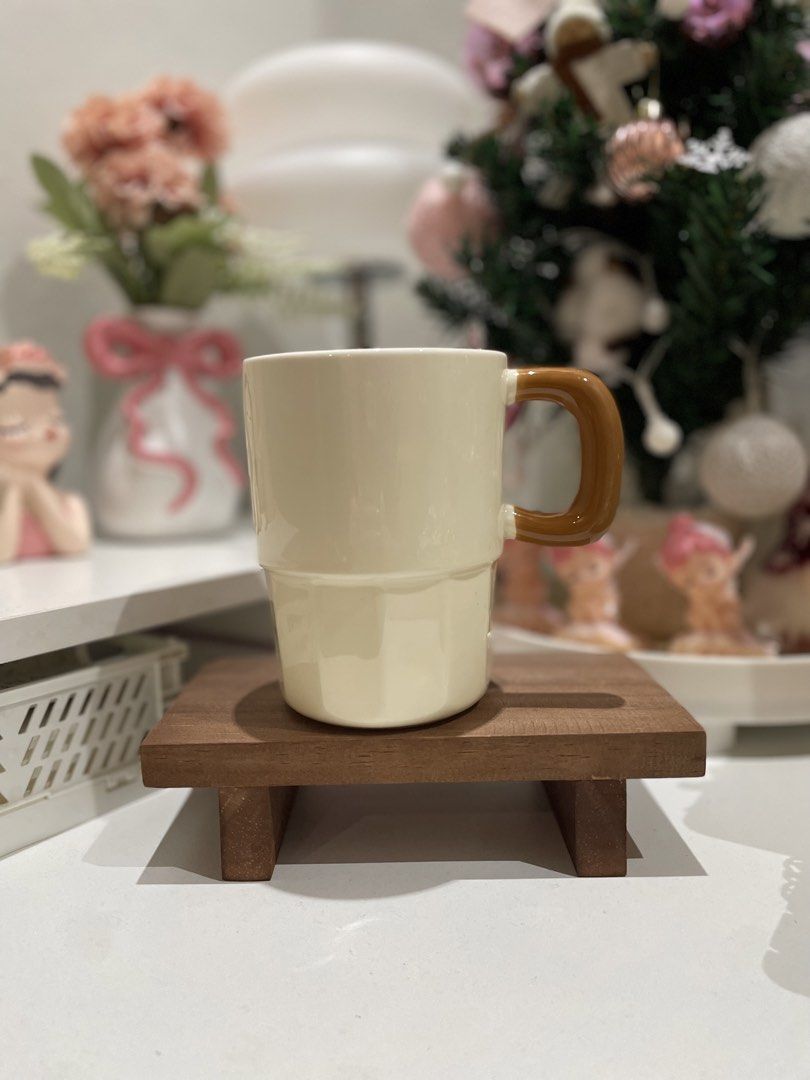 Cream Ceramic Mug with Brown Handle (Category: Coffee & Tea Tableware) located in Quezon City. Submitted by mugs.meowph (Listing ID 1461288613, Image 1). Description: - Cute cream mug with a chunky brown handle. - Features a unique stacked design. - Includes a small wooden stand. - Perfect for your morning coffee or tea. - Great for display or everyday use..