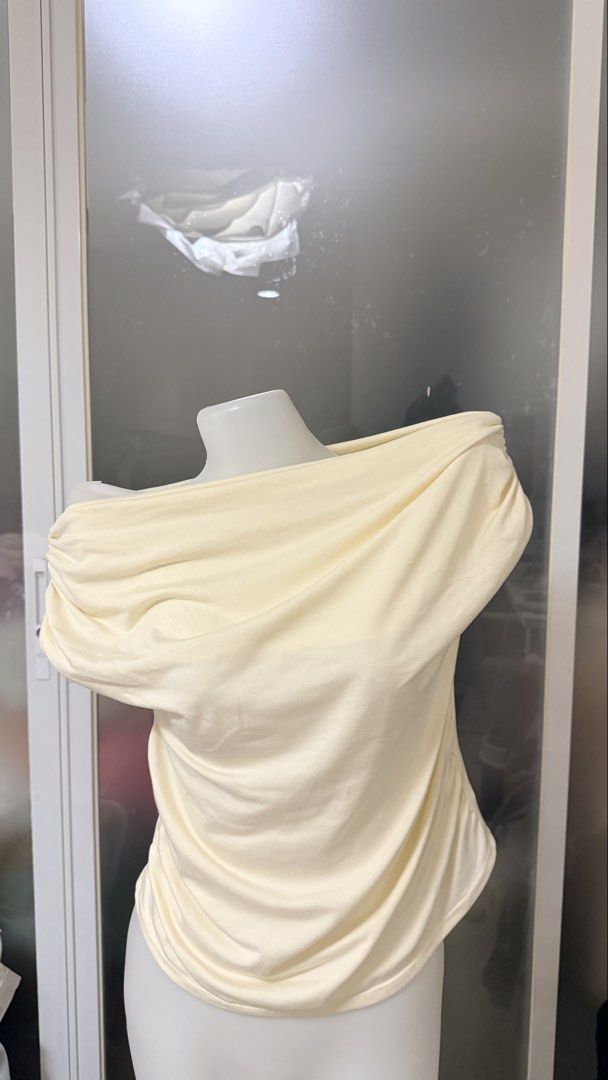 Cream Off-Shoulder Ruched Top (Category: Blouses) located in Manila. Submitted by vienayala295618 (Listing ID 1461235463, Image 1). Description: - Cream colored off-shoulder top - Features ruching details on sleeves and sides - Made with a soft, drapey fabric for comfort - Versatile style, perfect for dressing up or down.